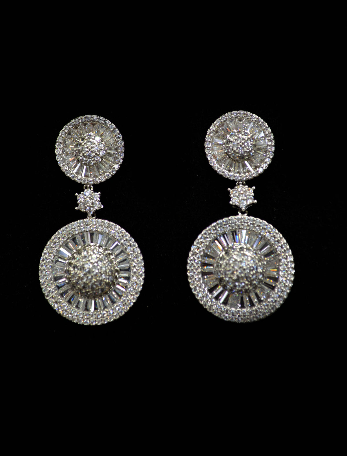 Round sunburst crystal earrings featuring brilliant stud paired with an open circular halo drop, product view at Rebecca’s…