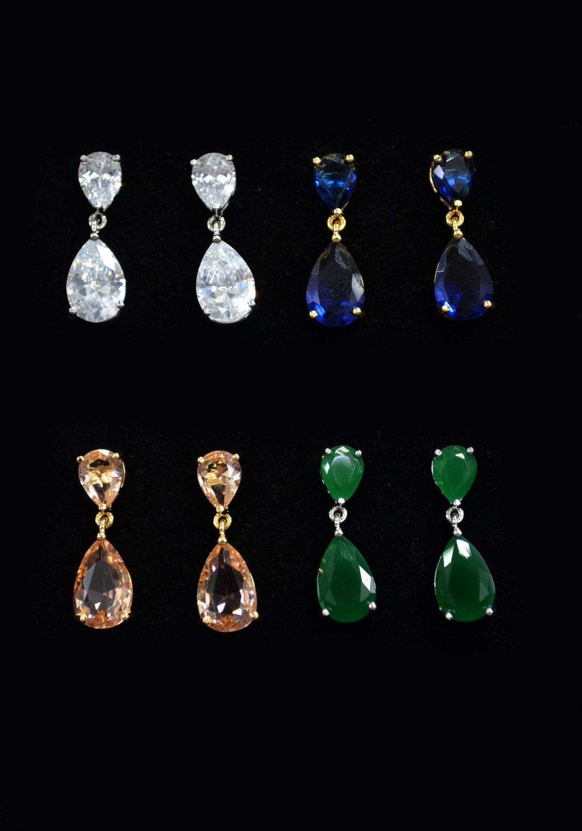 Pear-cut crystal studs in multiple colors featuring petite haloed teardrop offered in several jewel-tone options, product…