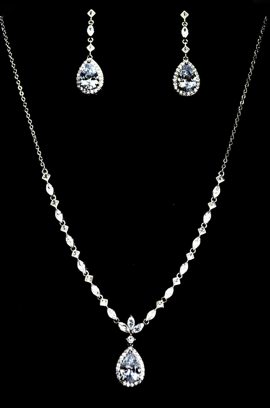 Three-piece teardrop crystal set featuring necklace, earrings, and bracelet with brilliant teardrop centers, product view…