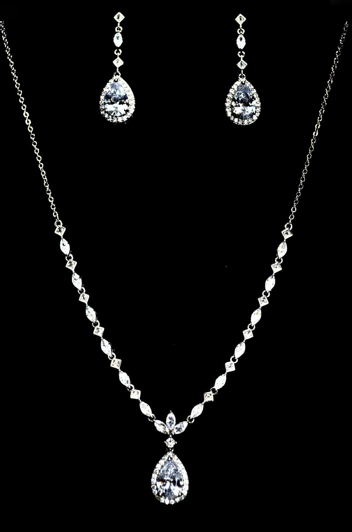 Three-piece teardrop crystal set featuring necklace, earrings, and bracelet with brilliant teardrop centers, product view…