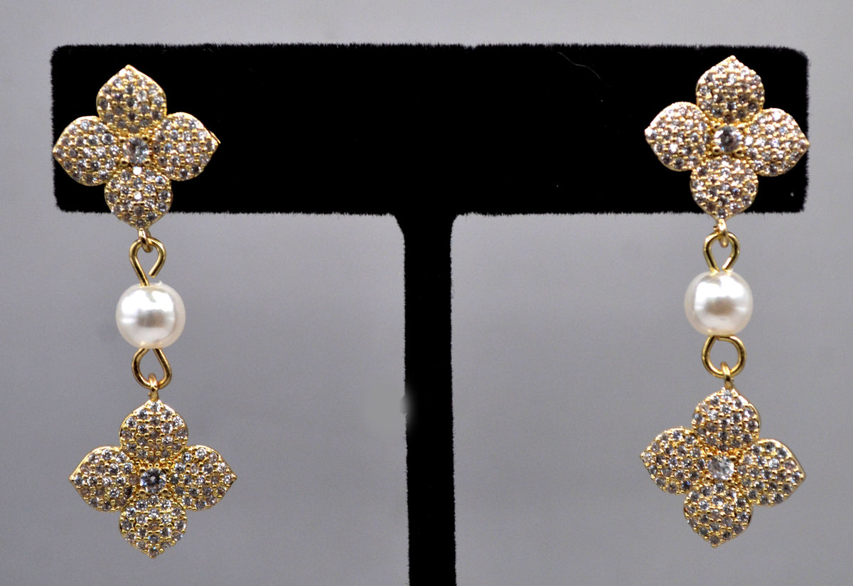Gold-tone floral pearl earrings featuring sparkling flower motif with a petite pearl drop, product view at Rebecca’s…