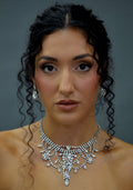 Statement crystal necklace-and-earring set featuring dramatic waterfall silhouette with marquise and teardrop stones,…