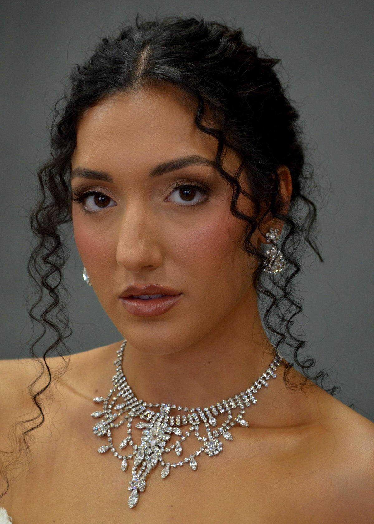 Statement crystal necklace-and-earring set featuring dramatic waterfall silhouette with marquise and teardrop stones,…
