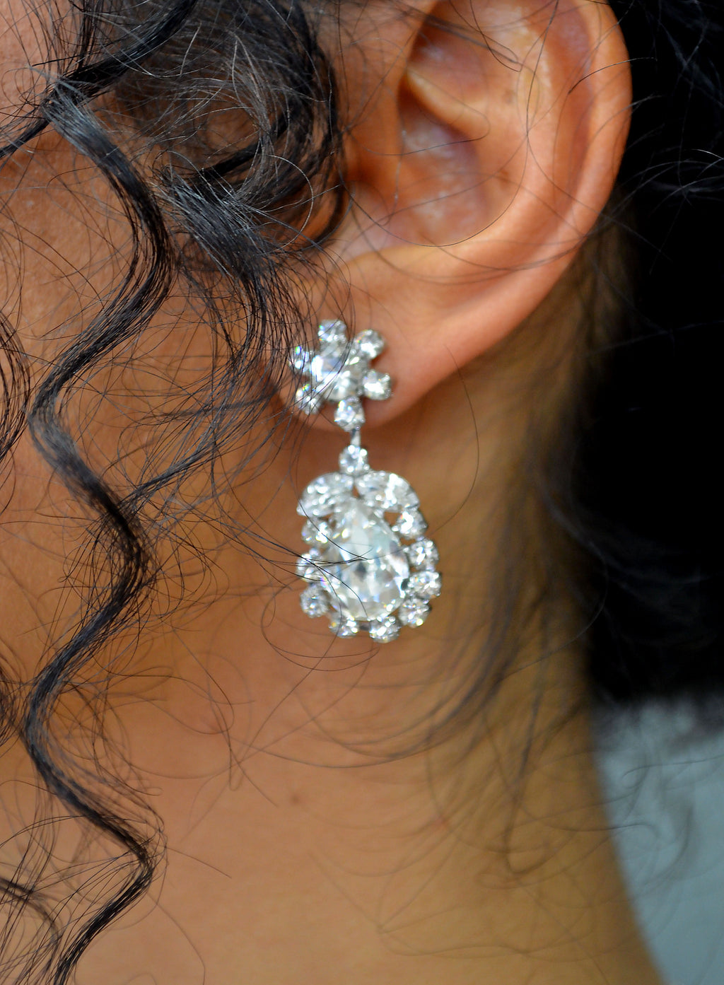 Statement crystal necklace-and-earring set featuring dramatic waterfall silhouette with marquise and teardrop stones, view…