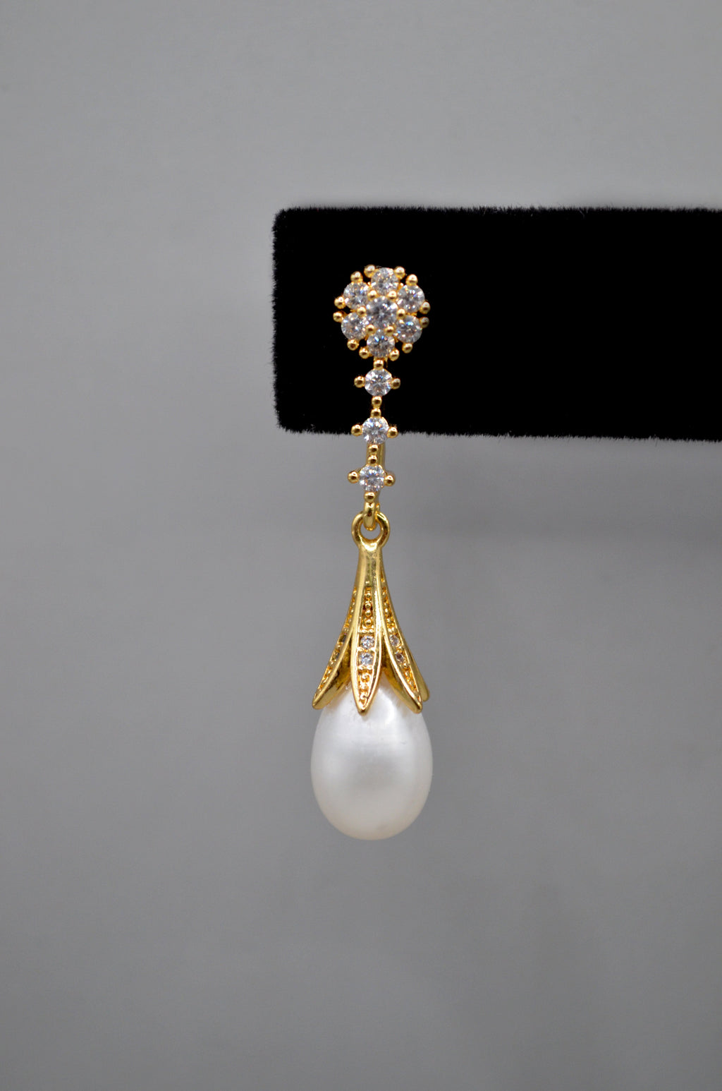 Pear-cut crystal drop earrings featuring faceted teardrop stone beneath a petite geometric crystal top, product view at…