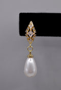 Pearl teardrop earrings featuring luminous pear-shaped pearl suspended from a petite crystal setting, detail view at…