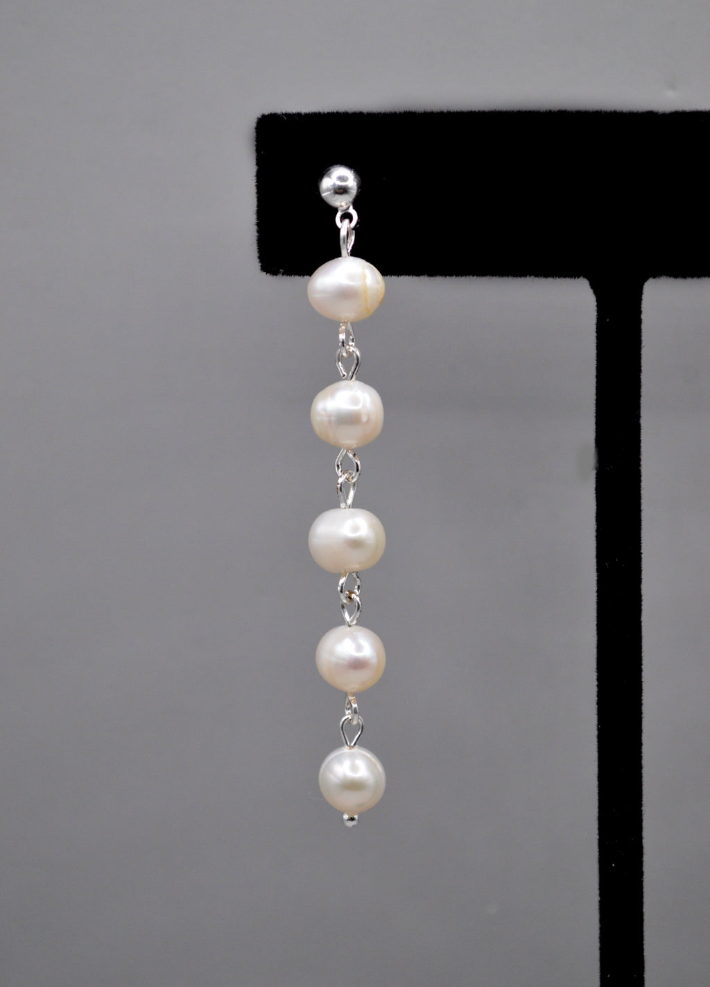 Long pearl strand earrings featuring graduated freshwater-style pearls linked in a graceful linear drop, alternate view at…