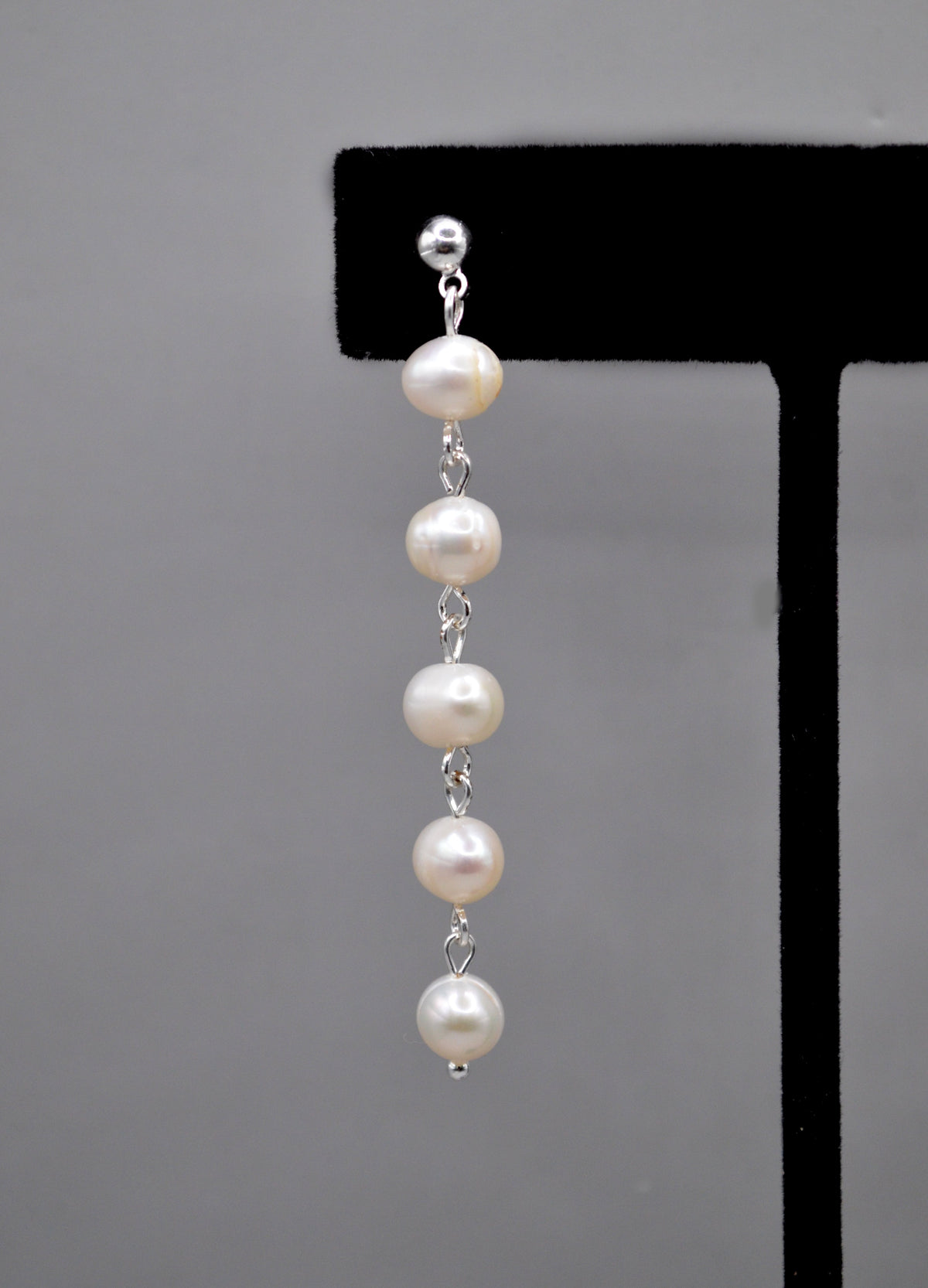 Long pearl strand earrings featuring graduated freshwater-style pearls linked in a graceful linear drop, alternate view at…