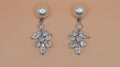 Pearl and rhinestone drop earrings featuring petite pearl stud with a romantic crystal leaf drop, product view at Rebecca’s…