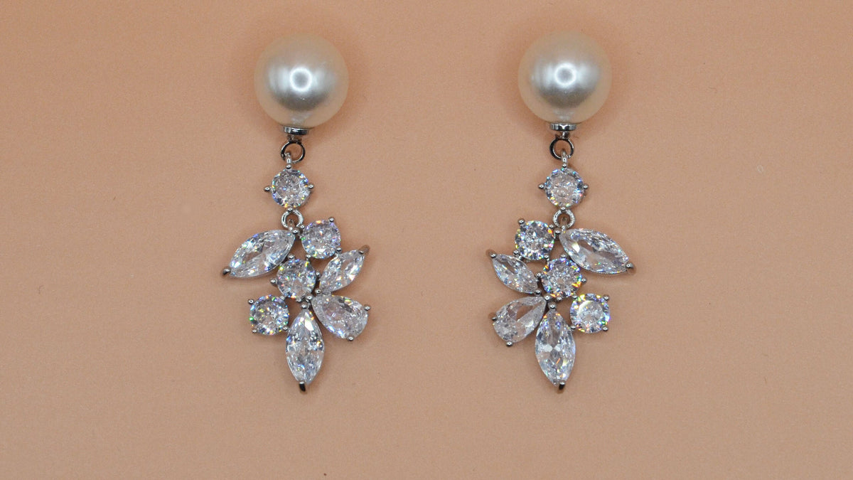 Pearl and rhinestone drop earrings featuring petite pearl stud with a romantic crystal leaf drop, product view at Rebecca’s…