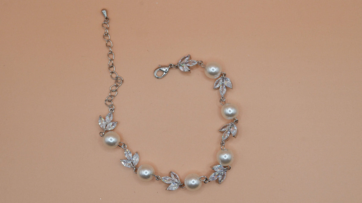 Pearl and rhinestone bracelet featuring airy vine of pearls and crystal leaves with an adjustable chain, product view at…