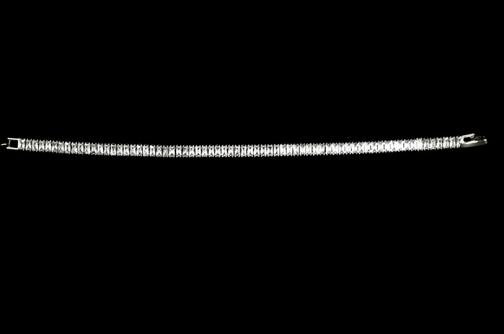 Baguette crystal tennis bracelet featuring continuous line of rectangular stones in a sleek setting, alternate view at…