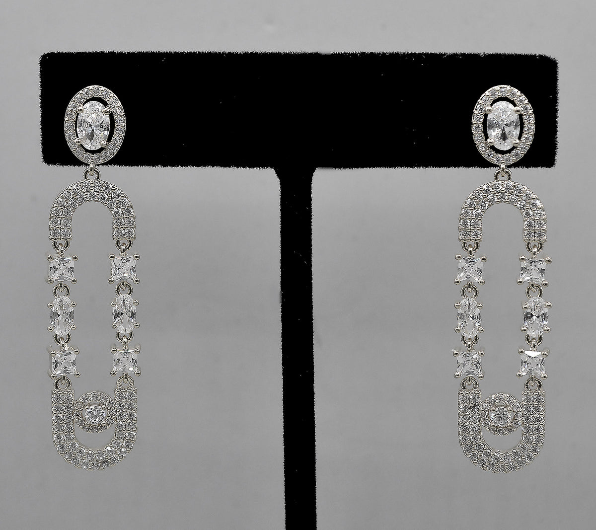 Double-loop crystal earrings featuring elongated linked loops covered in petite sparkling stones, detail view at Rebecca’s…