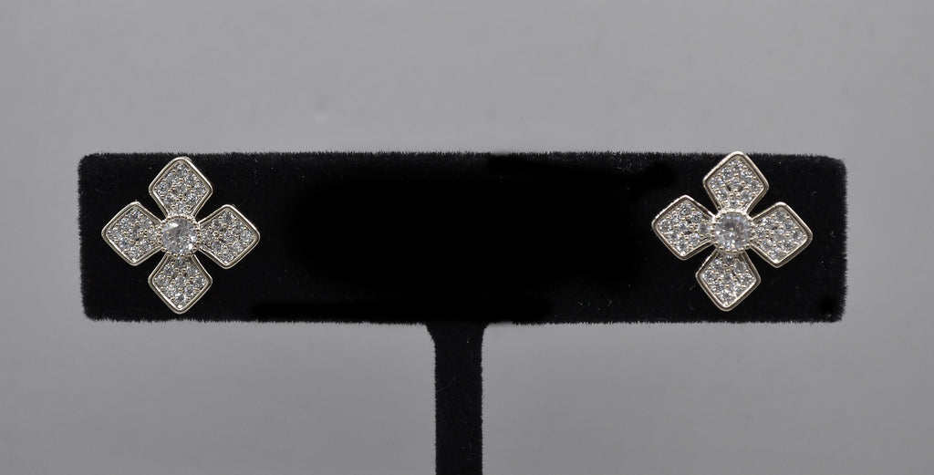 Geometric crystal clover studs featuring four square-cut stones arranged in a modern floral cross, product view at…