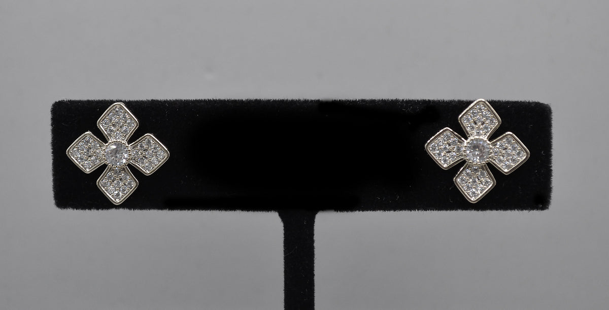 Geometric crystal clover studs featuring four square-cut stones arranged in a modern floral cross, product view at…