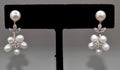 Pearl flower drop earrings featuring pearl stud with a delicate cluster of pearls and crystal leaves, product view at…