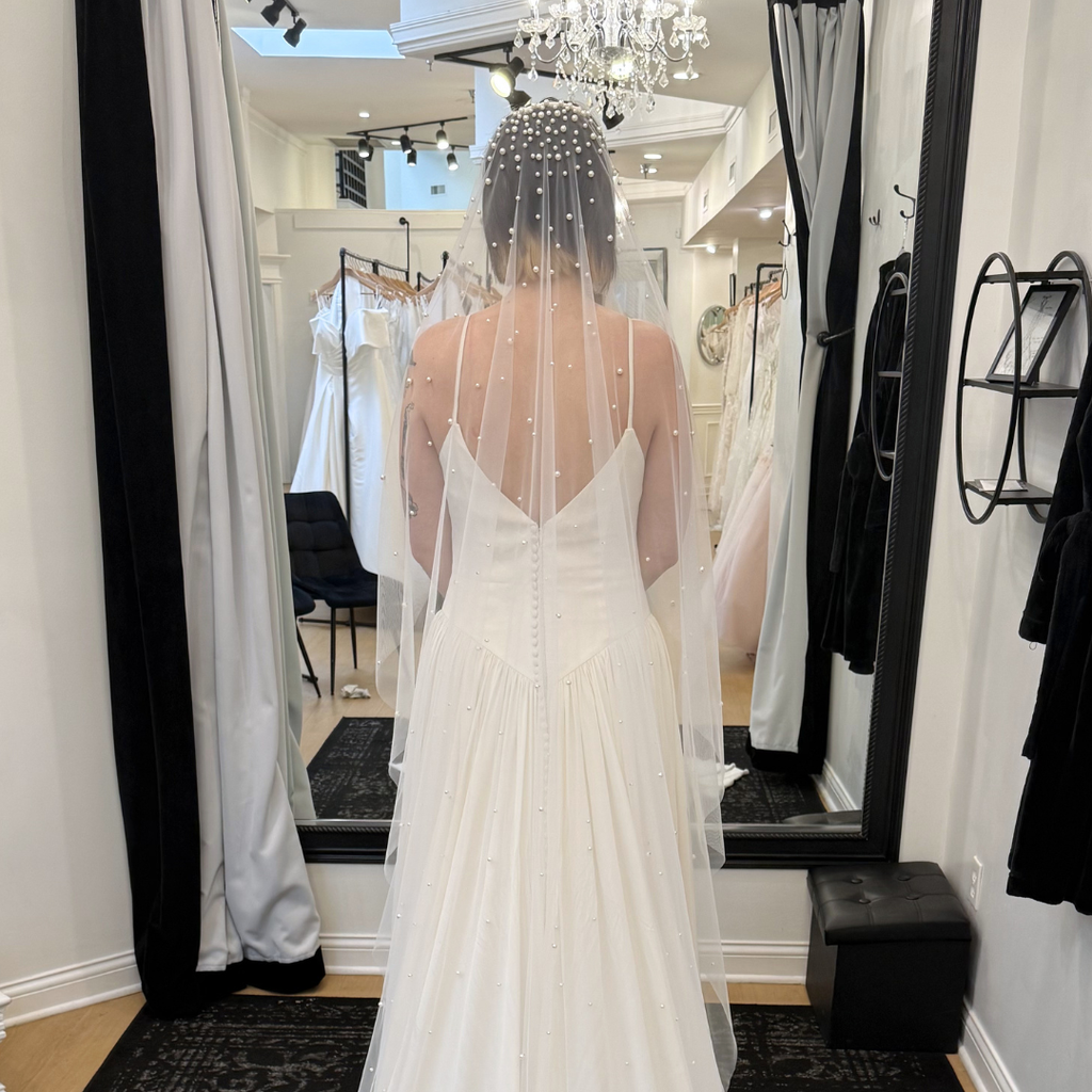 Cathedral-length pearl bridal veil with hand-placed pearls throughout ivory tulle. Modern wedding veil styled with a minimalist wedding gown at Rebecca's Wedding Boutique in Louisville, KY.