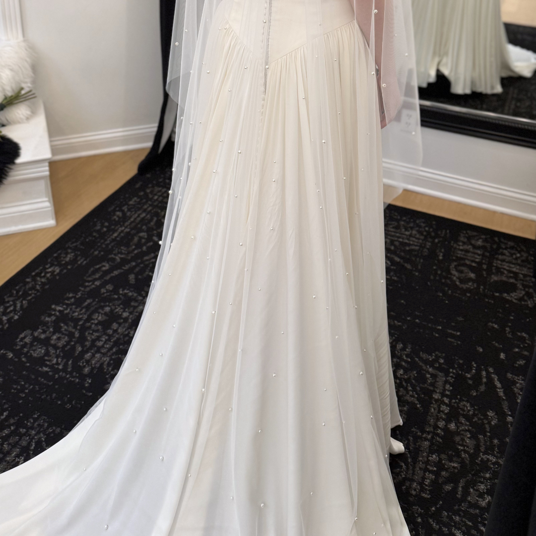 Cathedral-length pearl bridal veil with hand-placed pearls throughout ivory tulle. Modern wedding veil styled with a minimalist wedding gown at Rebecca's Wedding Boutique in Louisville, KY.